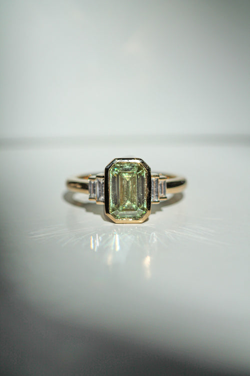 emerald cut green diamond in an art deco setting with white diamond baguette side stones (view 3)