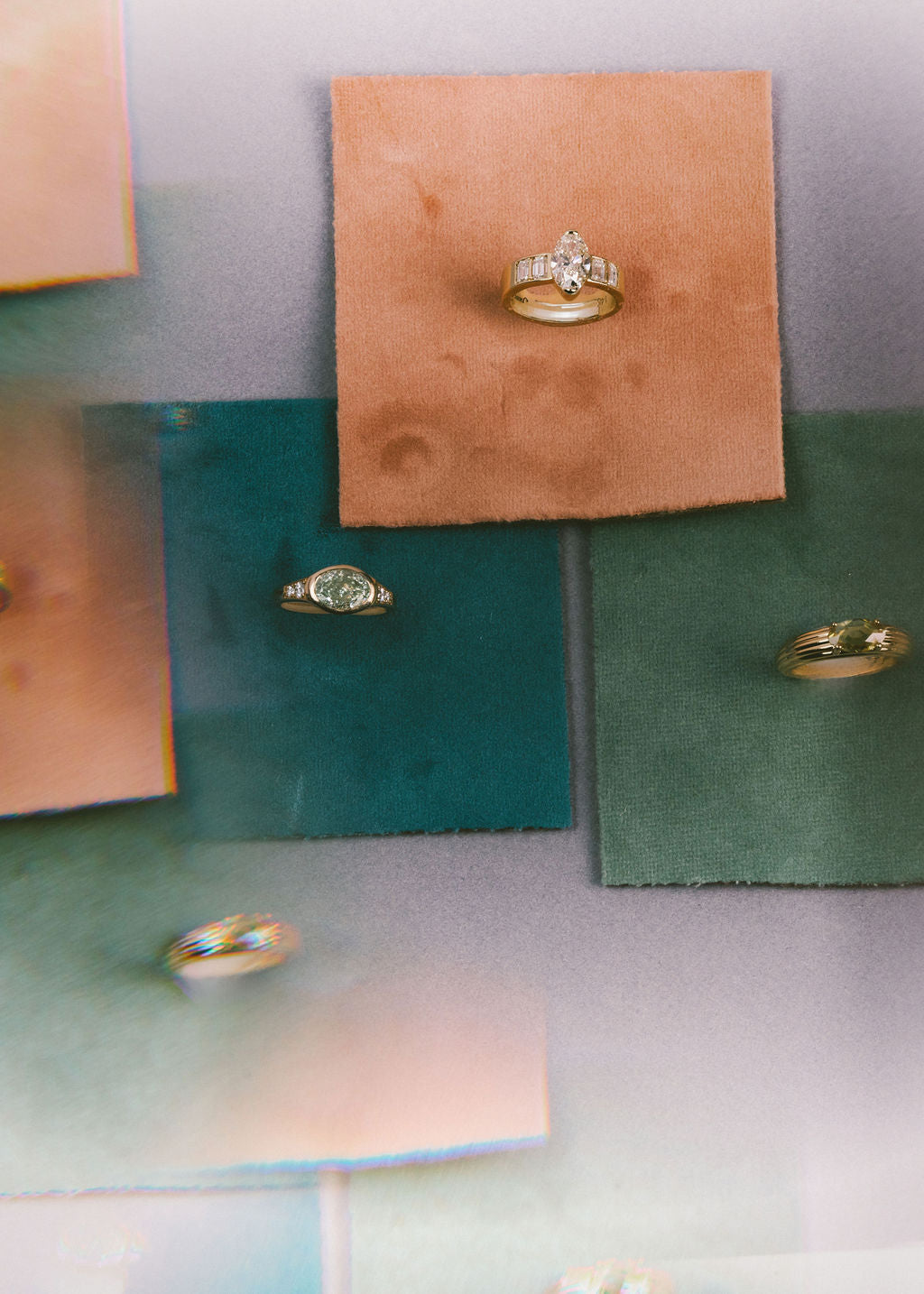 Gold rings with multi colored gemstones displayed on small square cards of different colors, including peach, teal, and sage green, against a soft lavender background. (view 9)